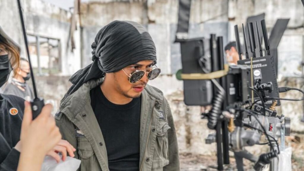 Namewee performing live on stage during a rap concert with microphone and crowd in background