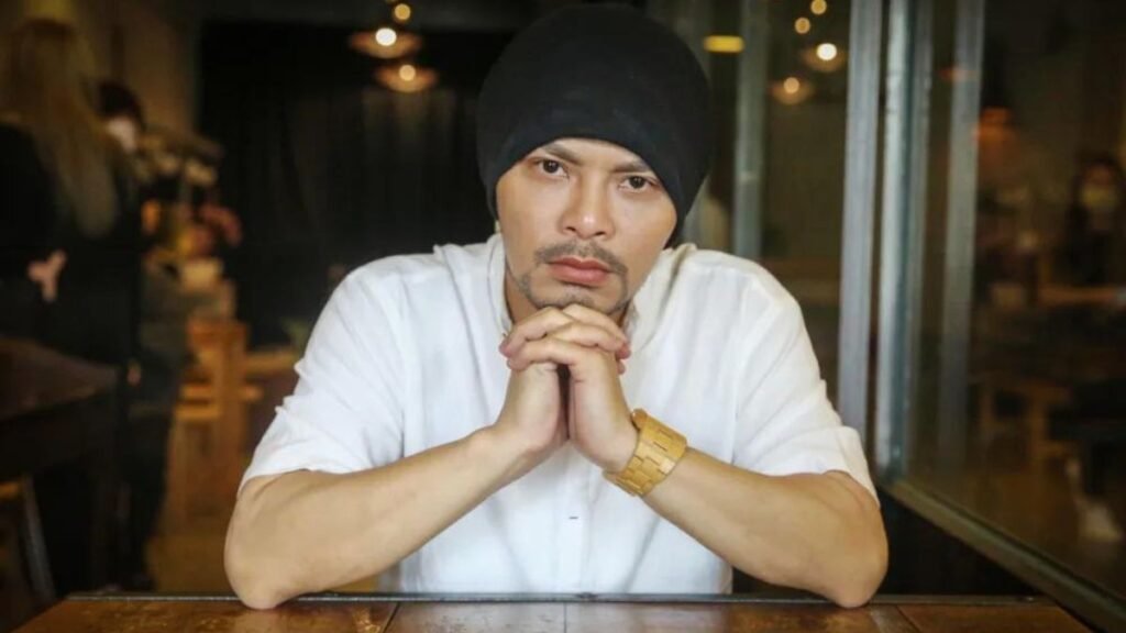 Namewee performing live on stage during a rap concert with microphone and crowd in background