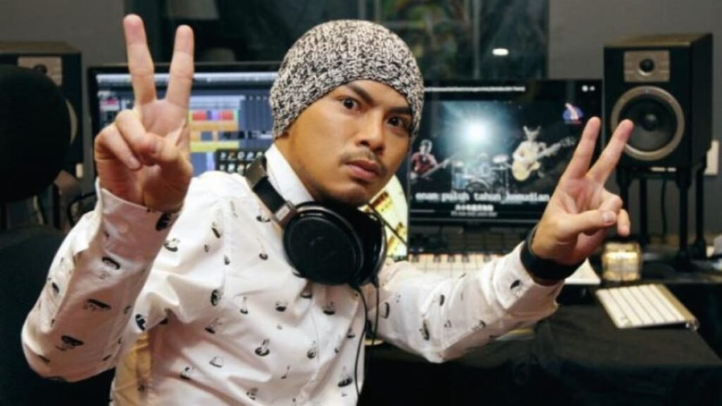 Namewee performing live on stage during a rap concert with microphone and crowd in background